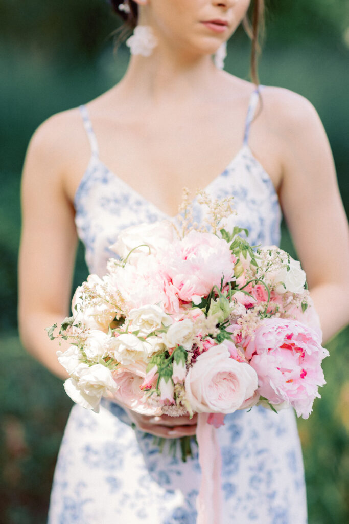 Bridesmaid holding bouquet, floral printed gown 