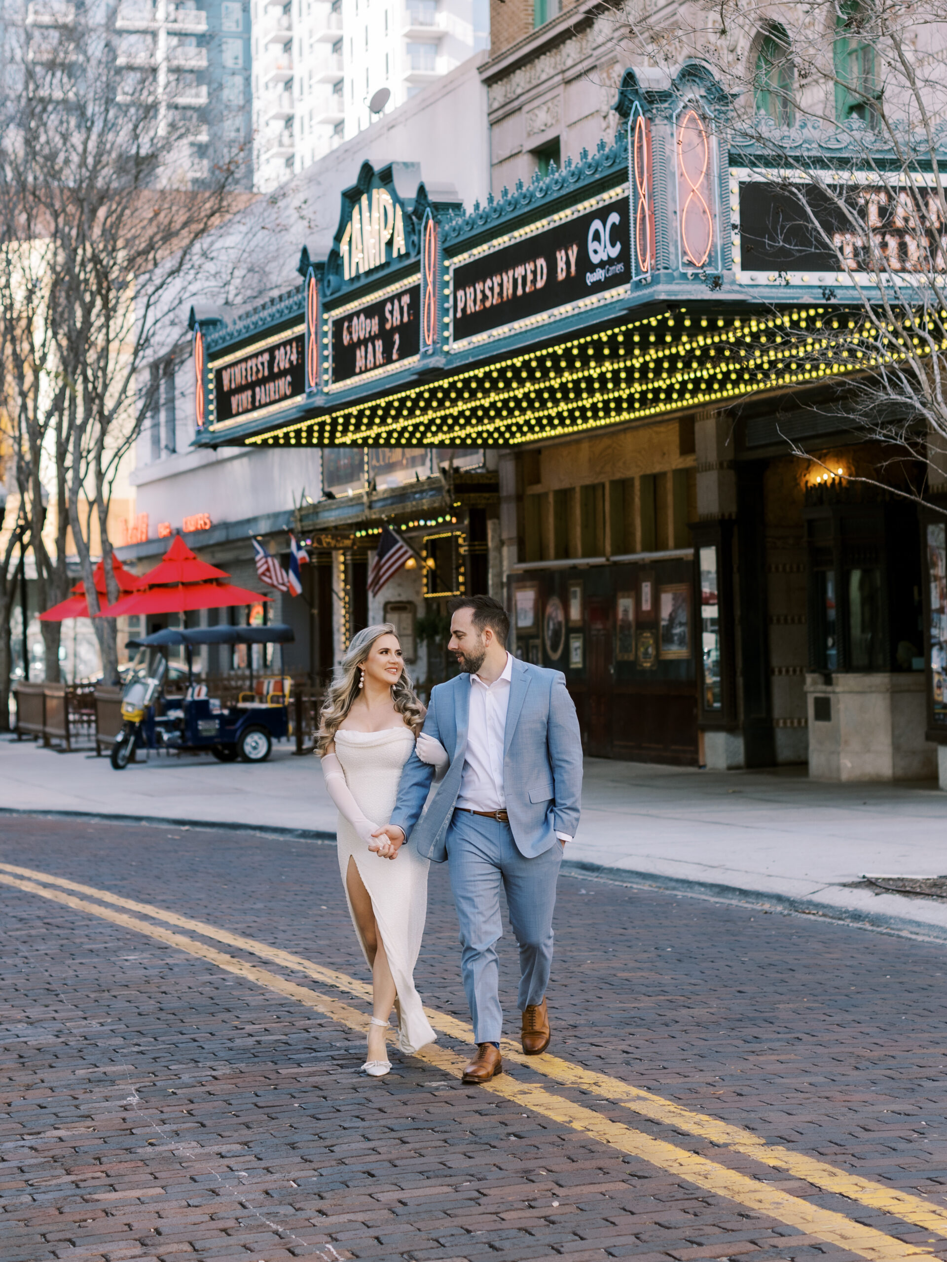 Couple leaving the Tampa Theatre in Downtown Tampa, wearing formal, stylish attire.